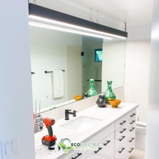 Bright hanging light fixture in bathroom above sink