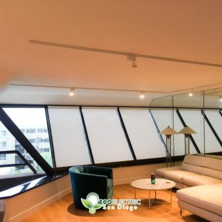 Angled windows in a room with track lighting