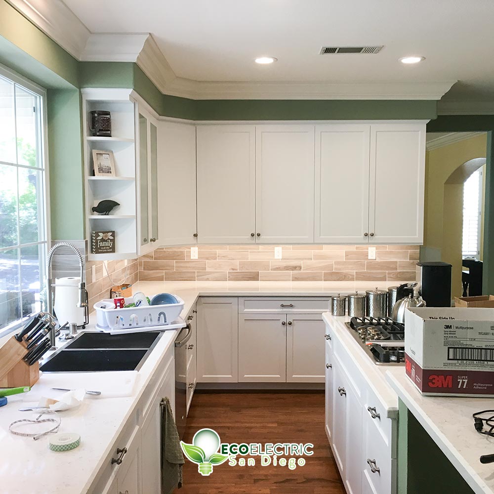 Green and white kitchen with recessed lighting