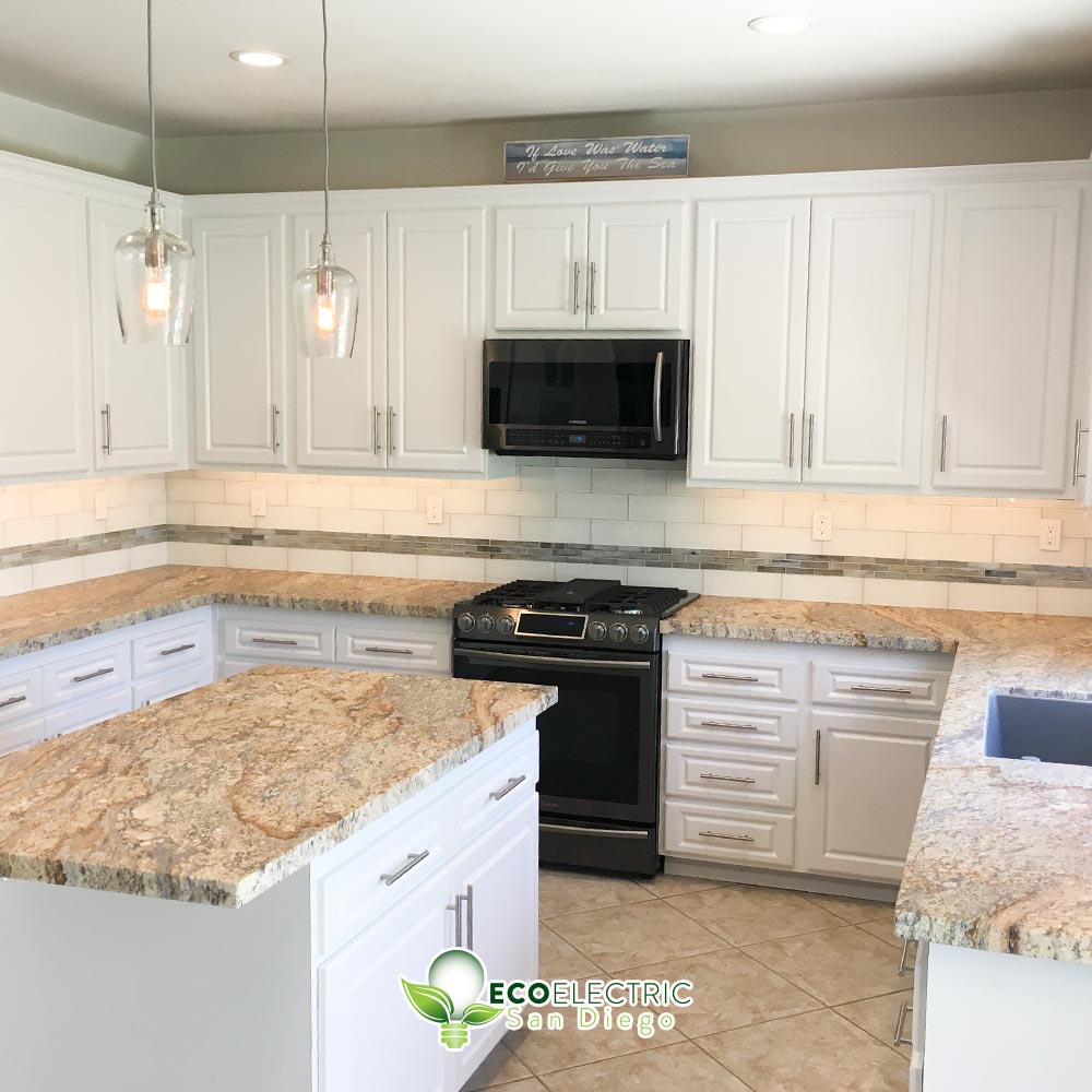 Kitchen shows recessed lighting and 2 hanging lights